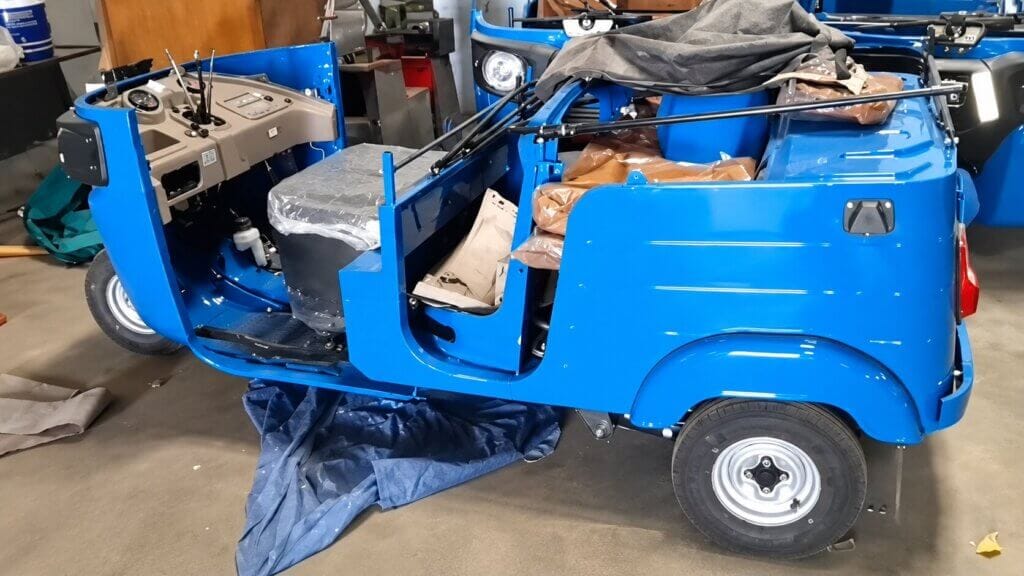 Bajaj RE 4S Compact auto rickshaw in SKD semi knocked down condition showing dashboard interior and passenger compartment ready for Africa export